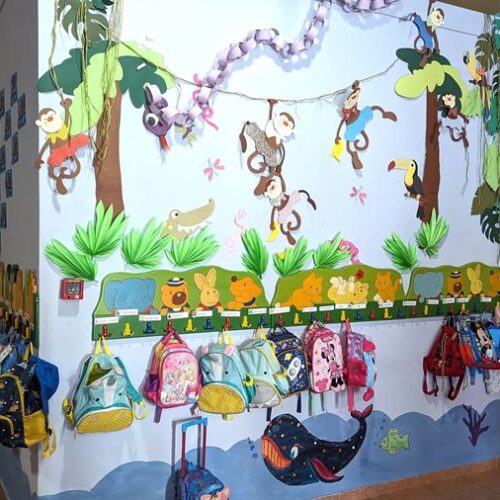 Οι τσάντες των νηπίων κρεμασμένες στον χρωματιστό τοίχο Παιδικού Σταθμού